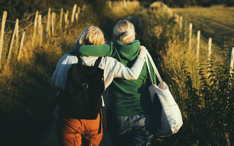 Two women, newly made friends, enjoying a peaceful nature walk near Chateau Charente, connecting with each other and the serene surroundings.